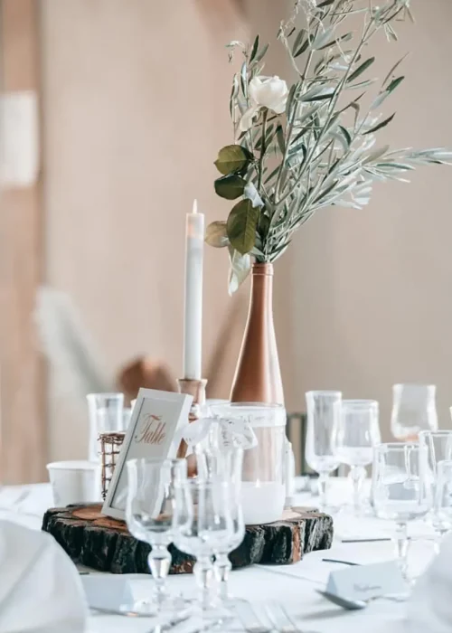 table joliment décorée avec un centre de table en bois, des bougies, des branches d'olivier et des roses- Traiteur - Régusse ( Var )